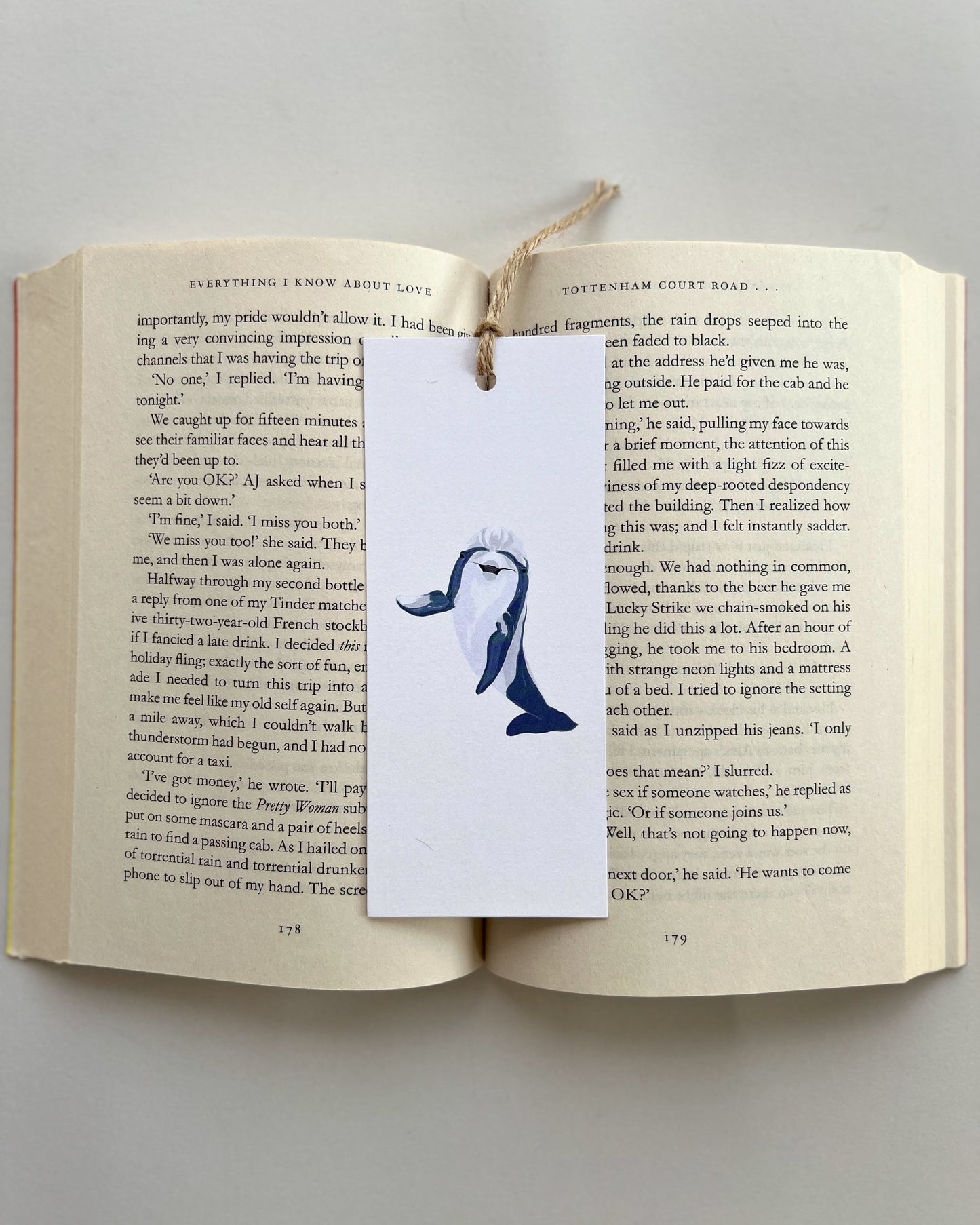 Open book with a bookmark featuring a dolphin illustration on a gray background