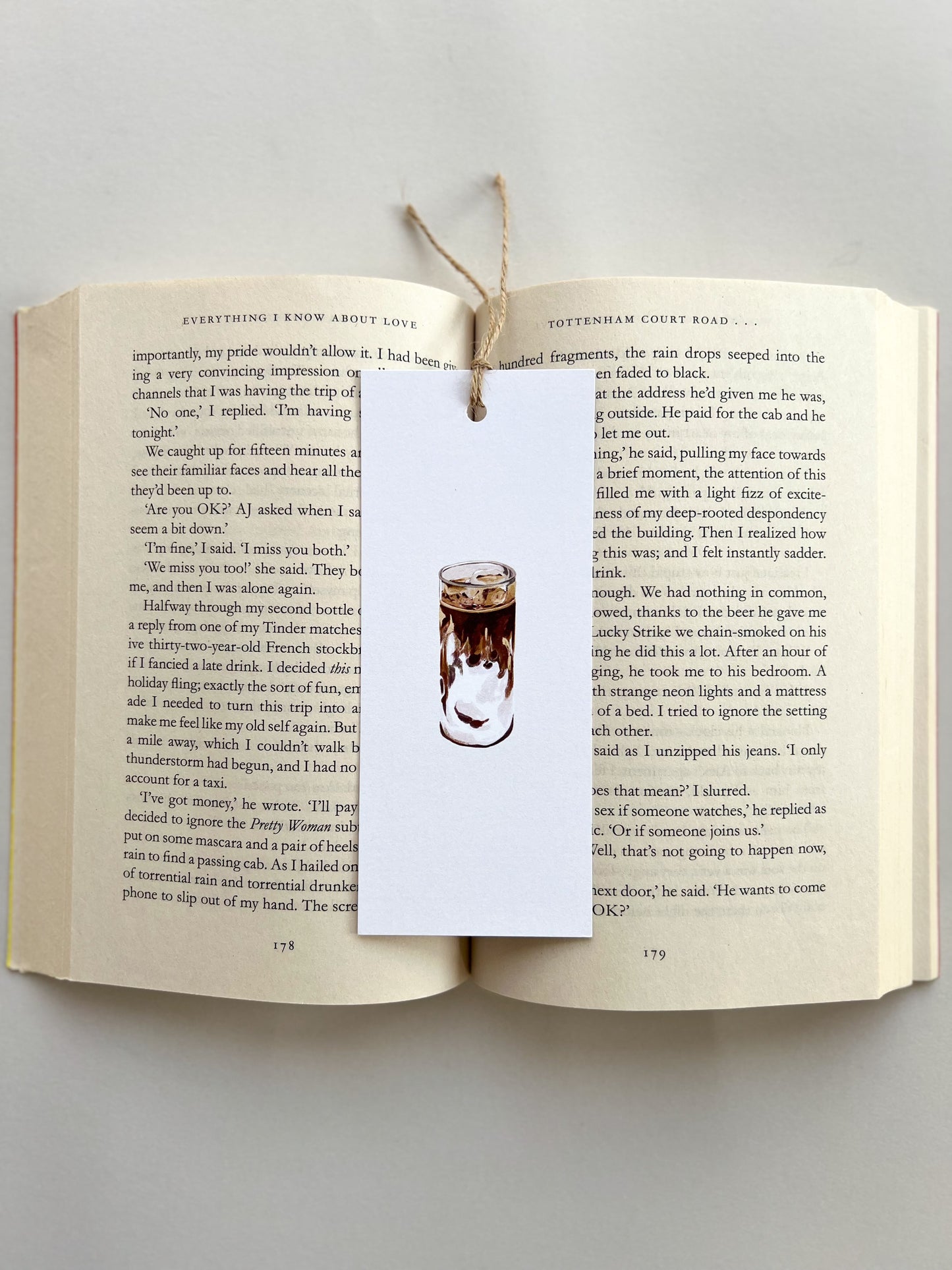 Open book with a bookmark featuring an illustration of a coffee cup on a gray background