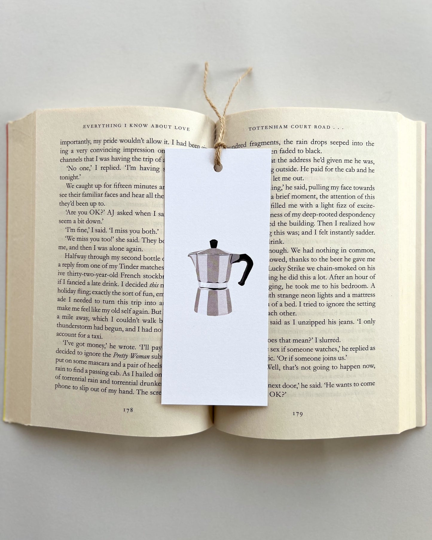 Open book with a bookmark featuring a Moka pot design on a light gray background