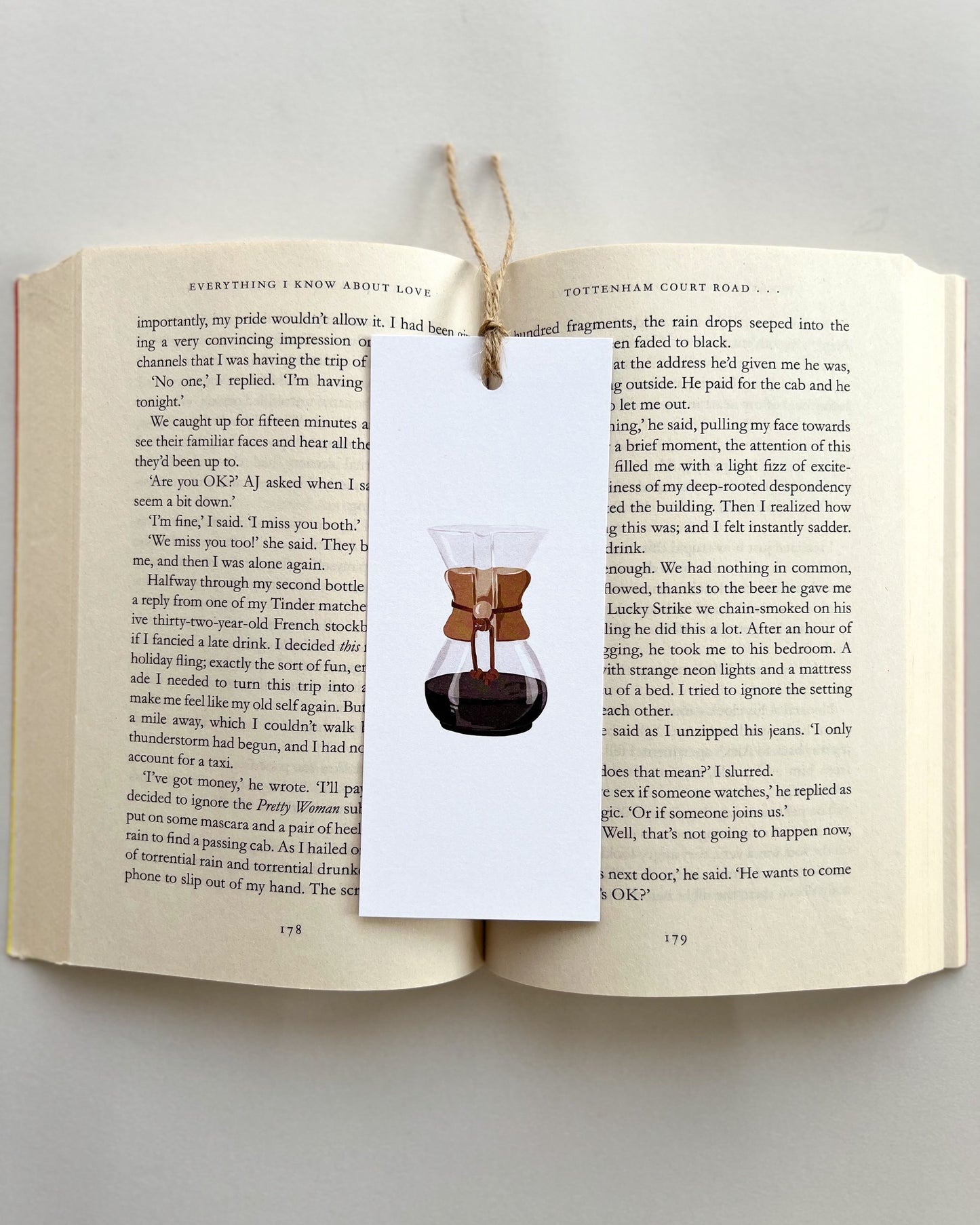 Open book with a bookmark featuring a coffee maker illustration on a light gray background