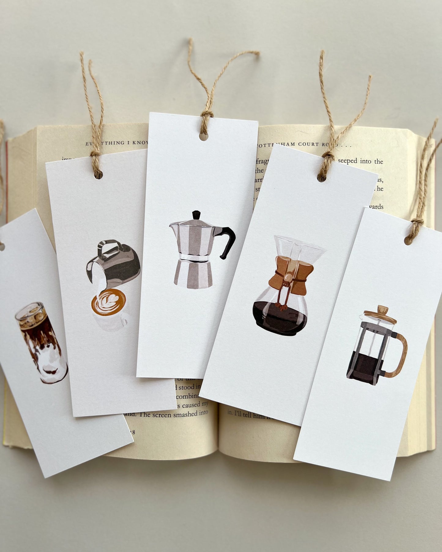 Set of coffee-themed bookmarks hanging from an open book