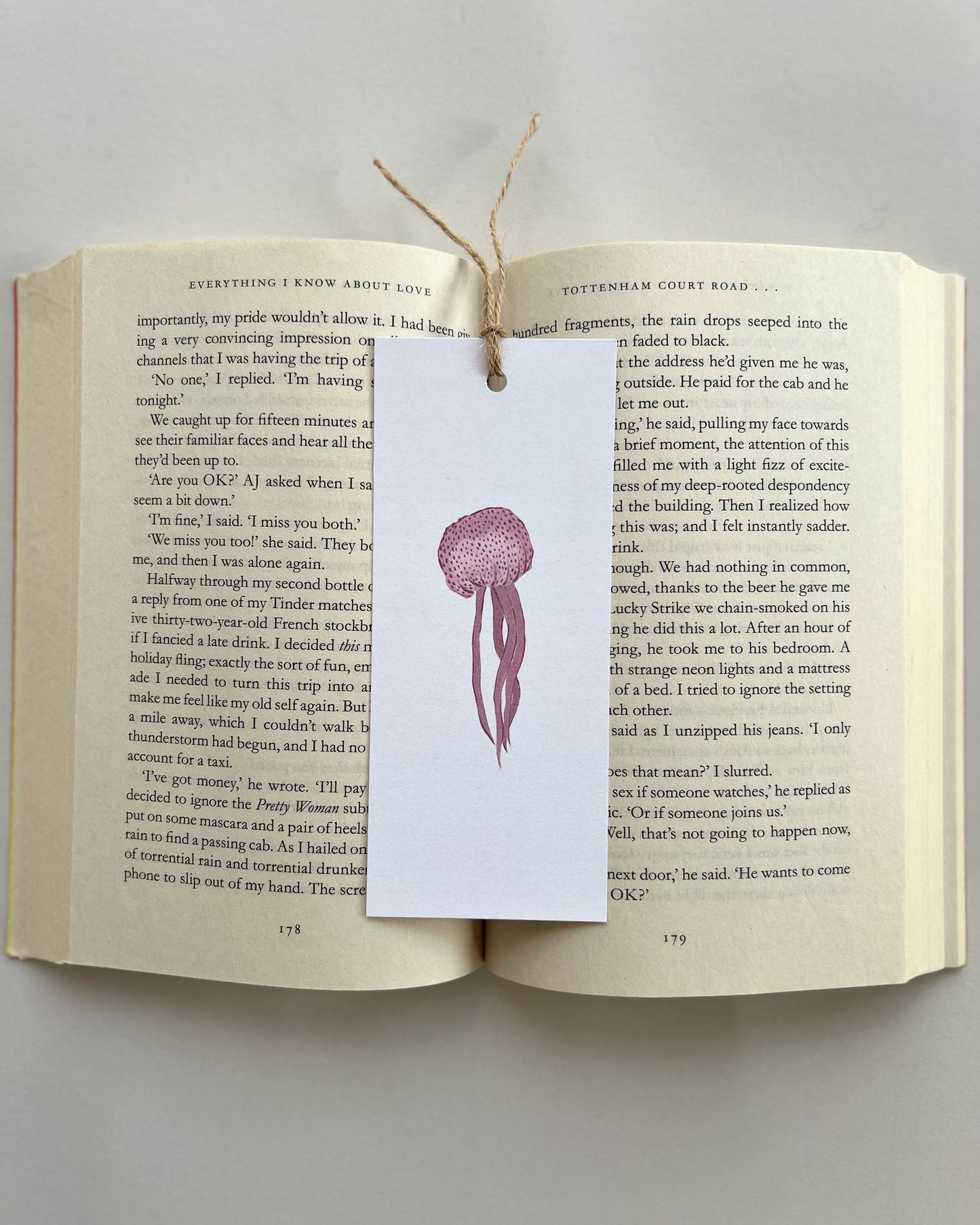 Open book with a jellyfish bookmark on a gray background
