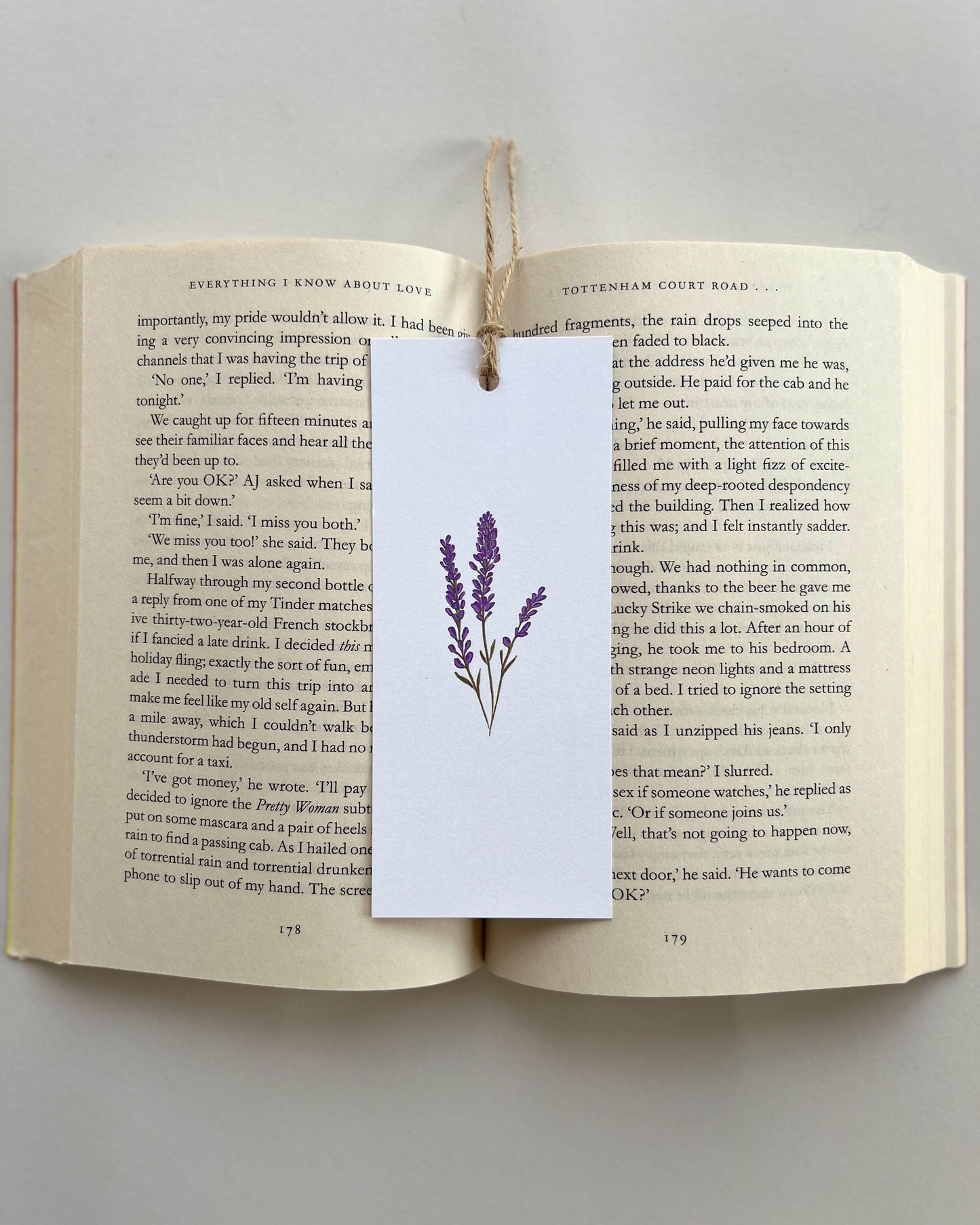 Open book with a purple lavender flower bookmark on a gray background