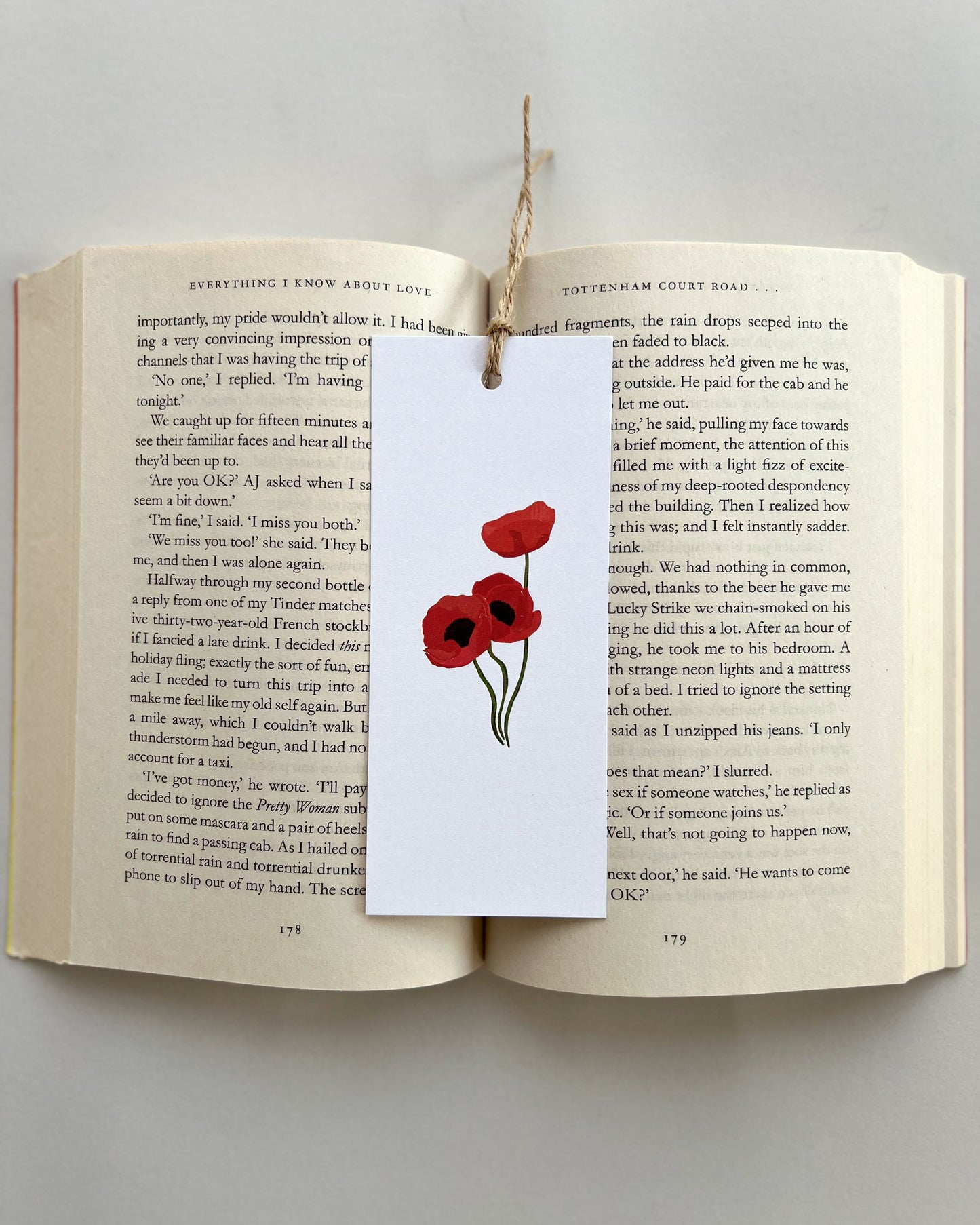 Open book with a bookmark featuring red poppies on a white background