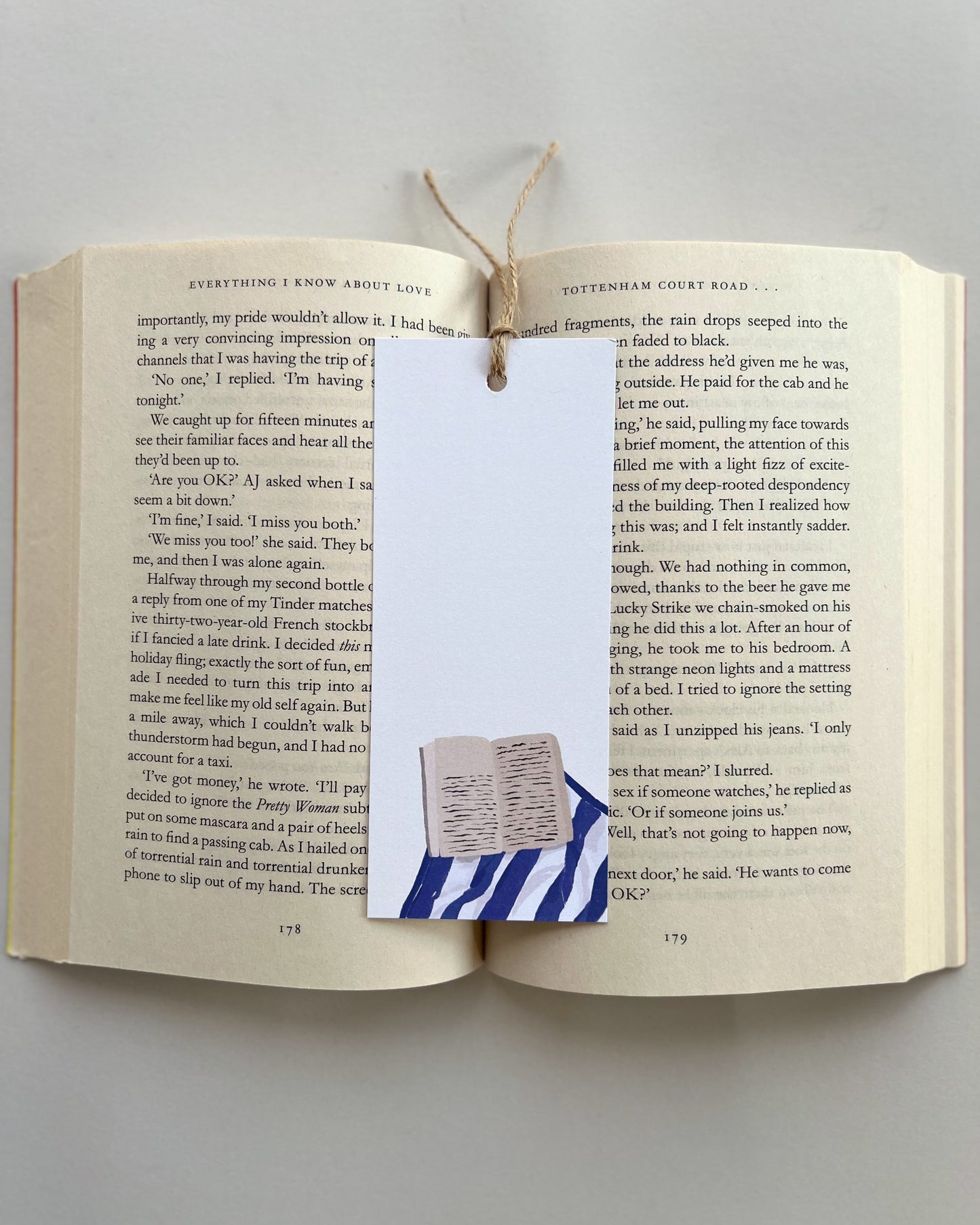 Open book with a bookmark featuring a small flag design on a plain background
