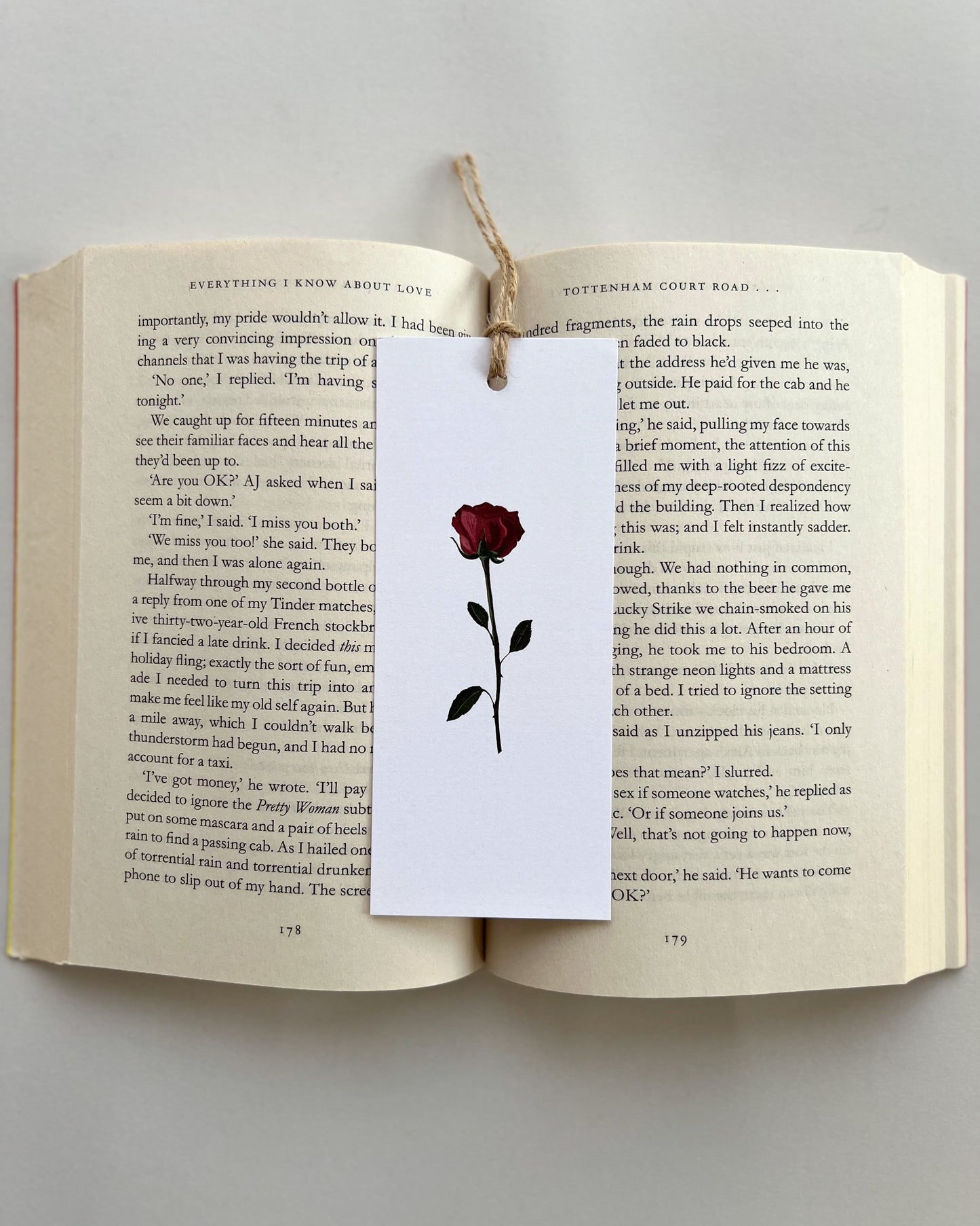 Open book with a bookmark featuring a red rose illustration on a white background