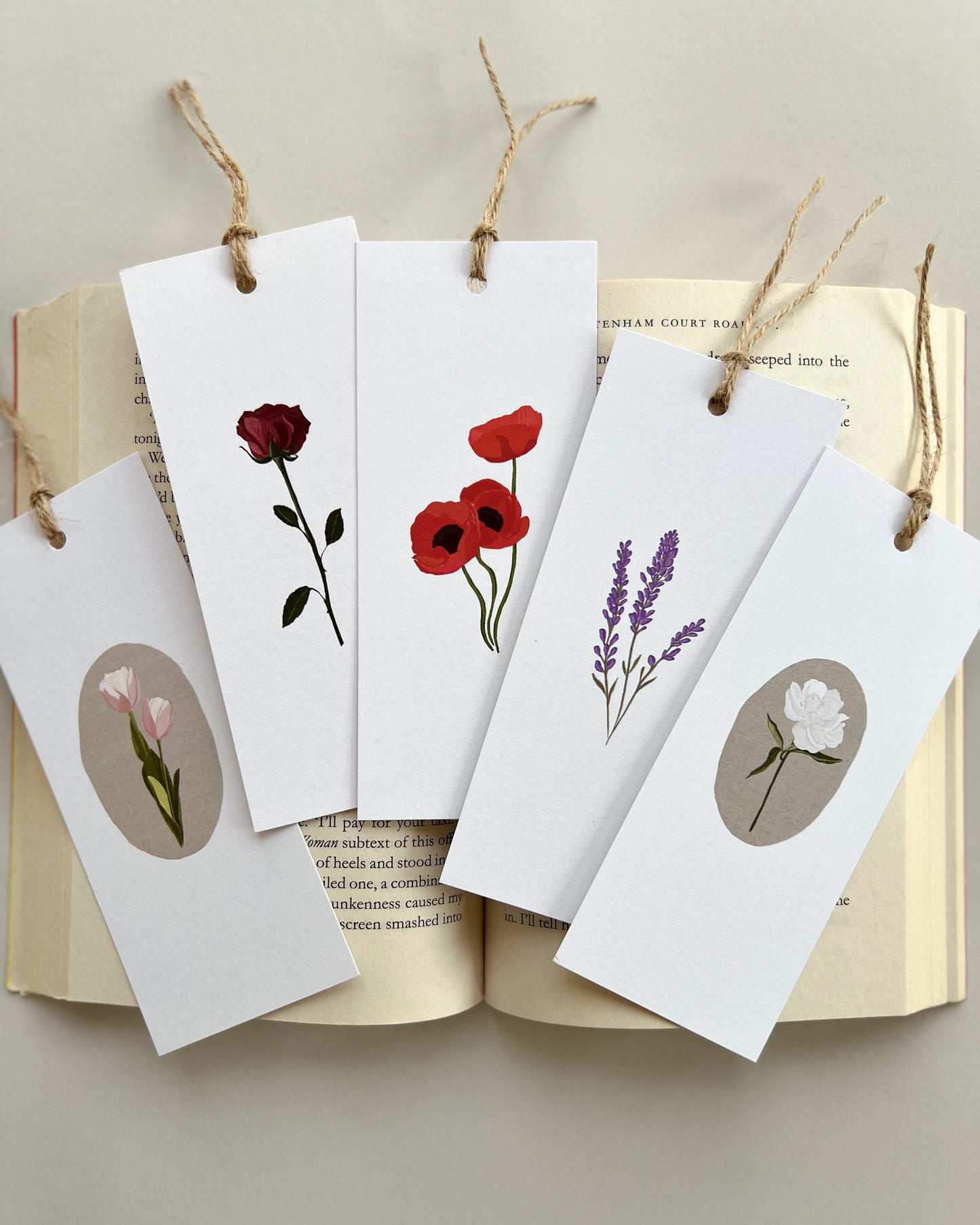Floral bookmarks on an open book with a neutral background