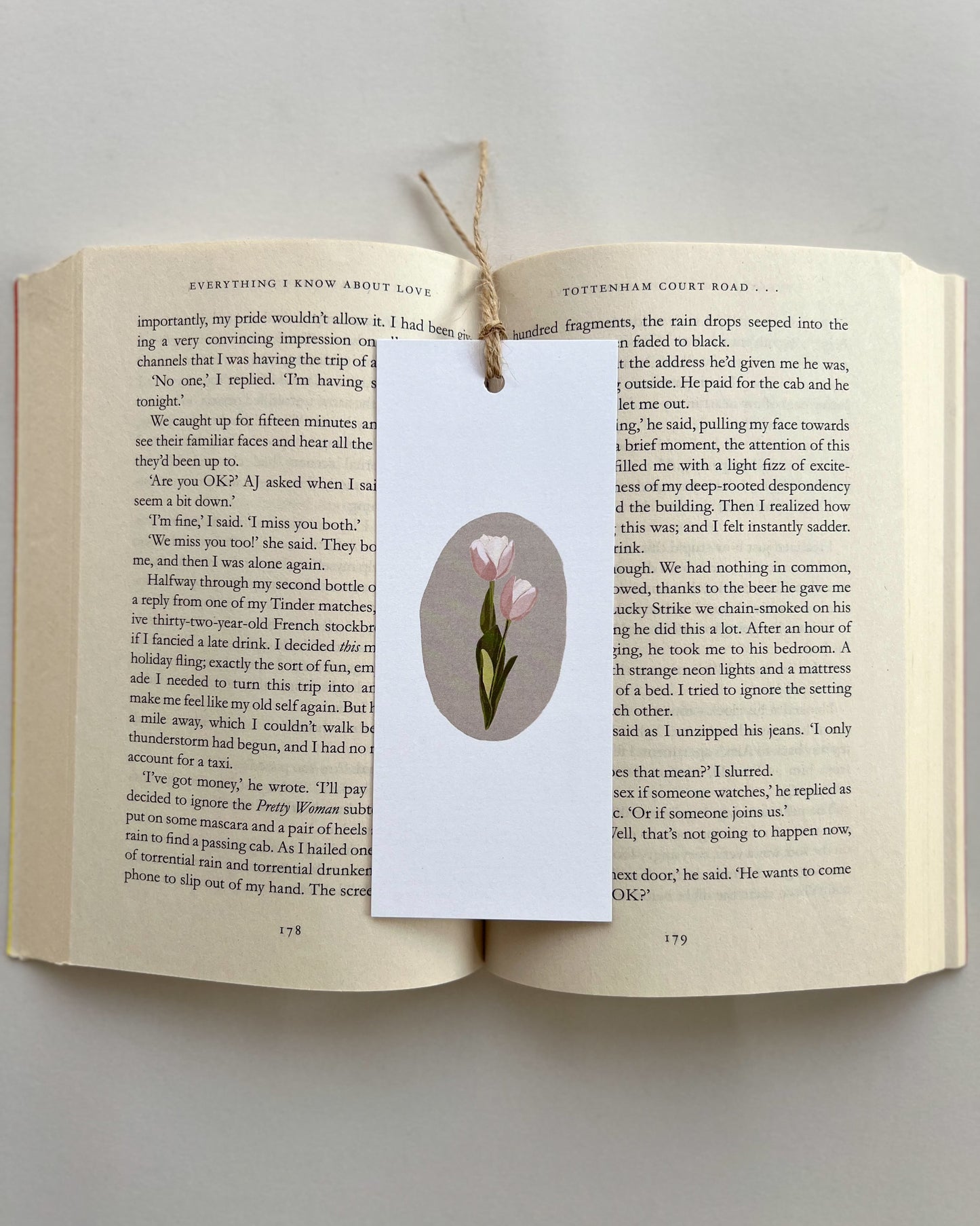 Open book with a bookmark featuring a tulip illustration on a gray background