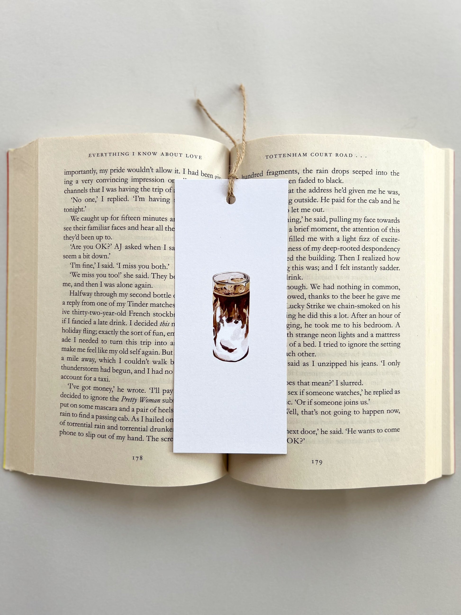 Open book with a bookmark featuring an illustration of a coffee cup on a gray background