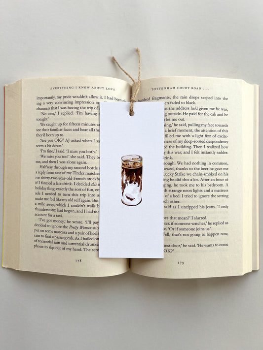 Open book with a bookmark featuring an illustration of a coffee cup on a gray background