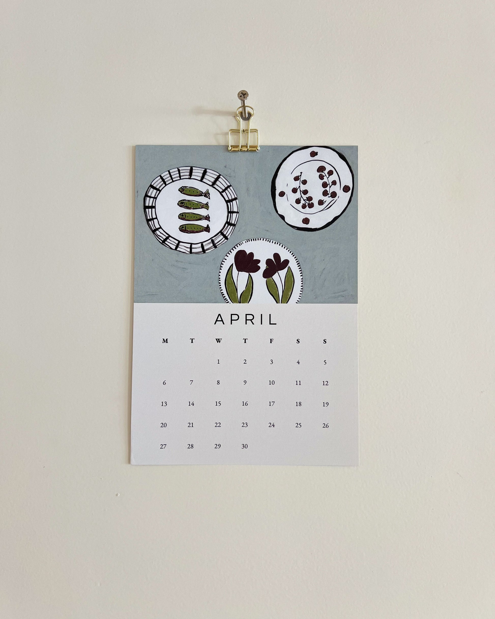 2026 Wall/Desk Calendar with April sketchbook original art/illustration of fishes and plates that represents the start of summer with a summer blue background.