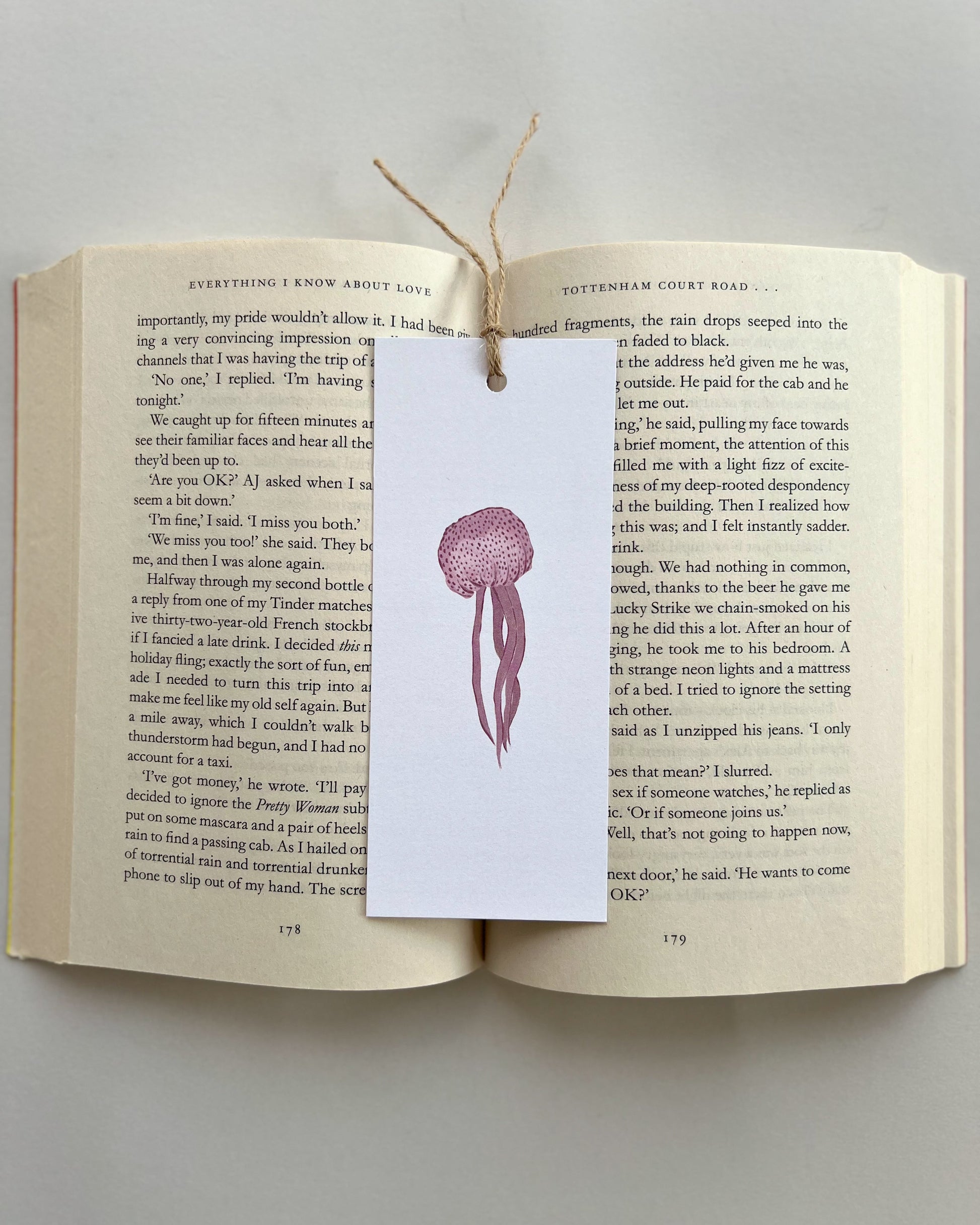 Open book with a jellyfish bookmark on a gray background
