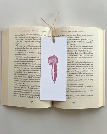 Open book with a jellyfish bookmark on a gray background