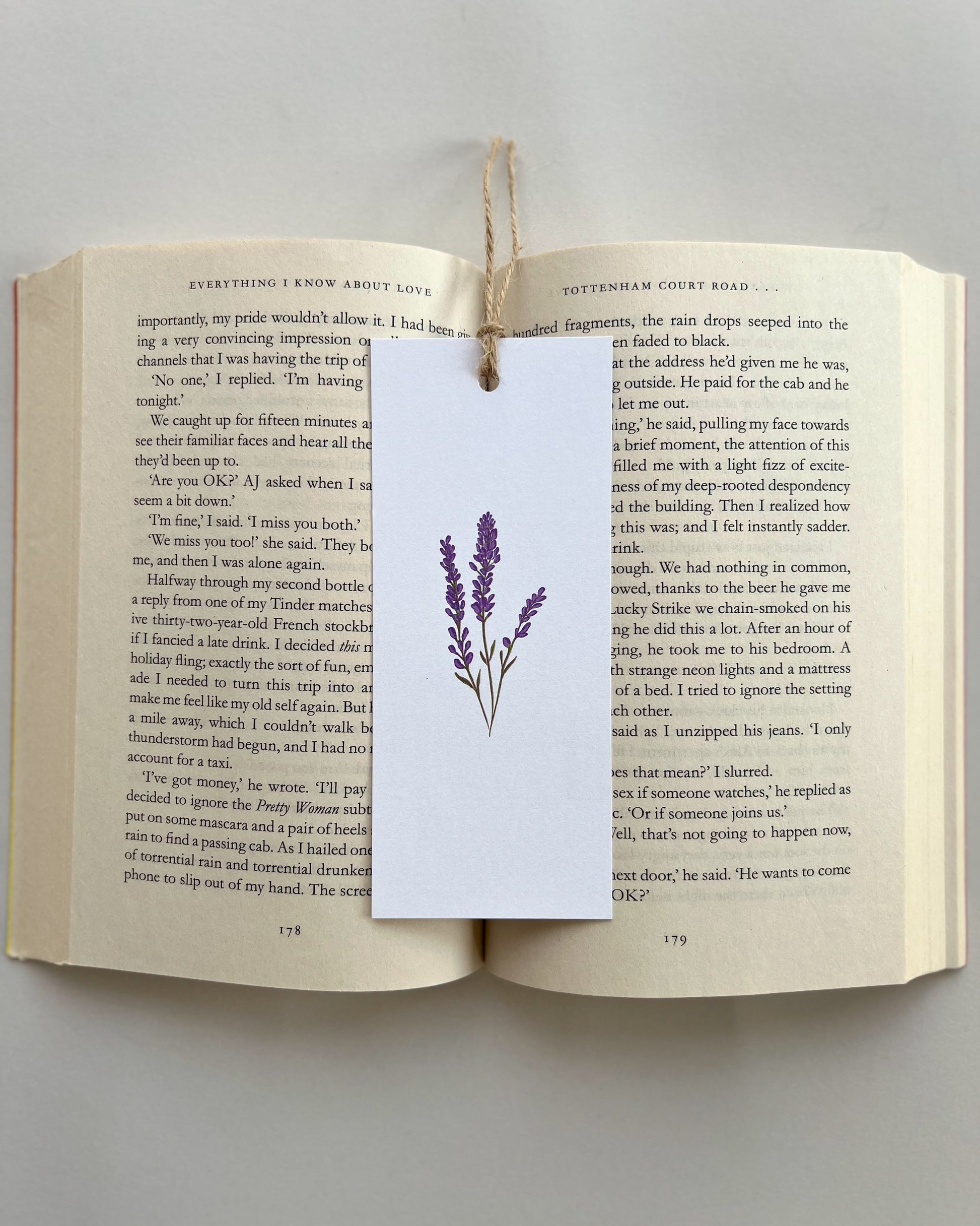 Open book with a purple lavender flower bookmark on a gray background