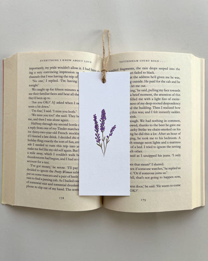 Open book with a purple lavender flower bookmark on a gray background