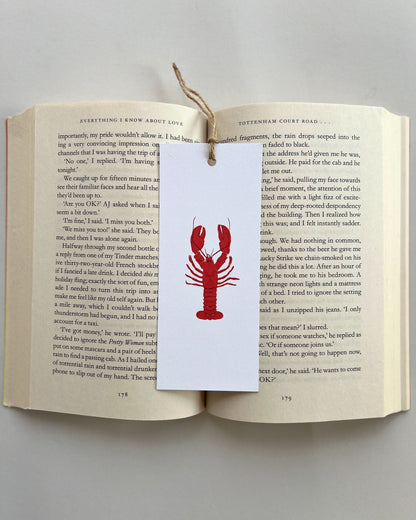 Open book with a red lobster bookmark on a white background