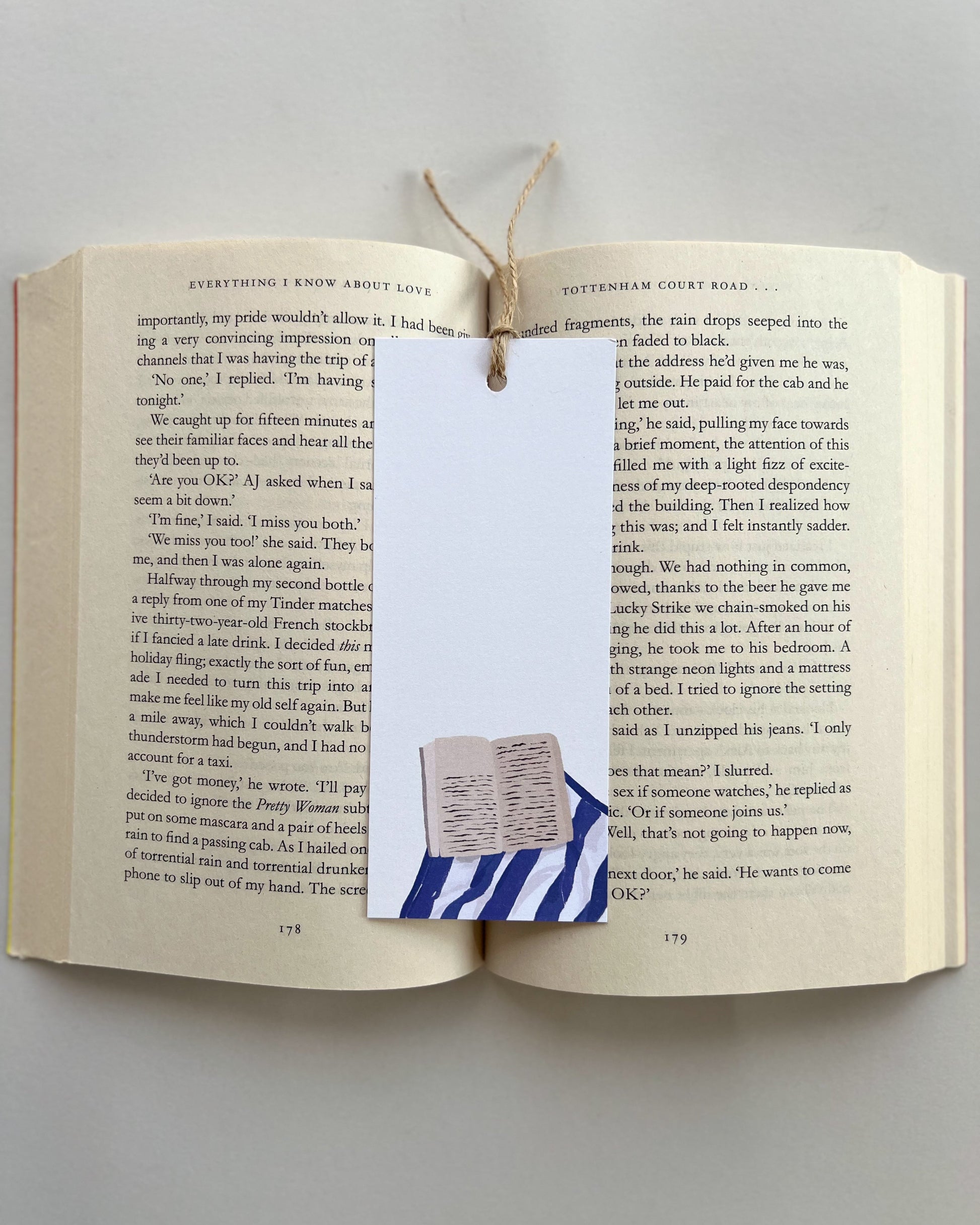 Open book with a bookmark featuring a small flag design on a plain background