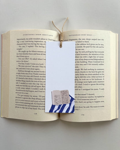Open book with a bookmark featuring a small flag design on a plain background